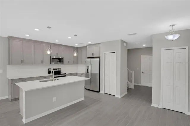 a kitchen with stainless steel appliances a refrigerator sink and microwave