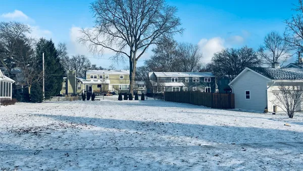 a view of a house with a yard covered in snow