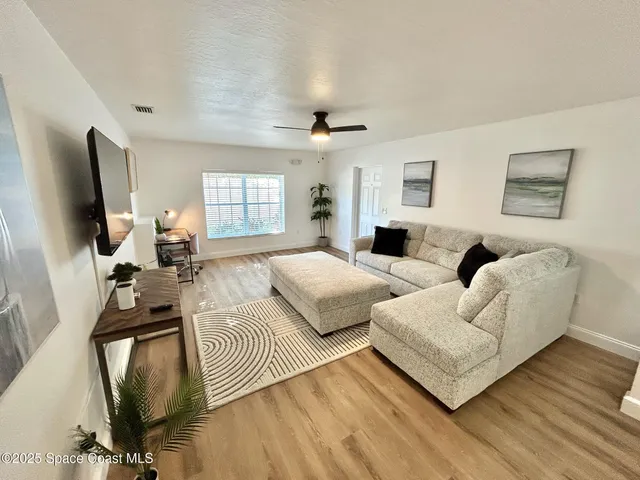 a large white kitchen with cabinets a sink a window and stainless steel appliances