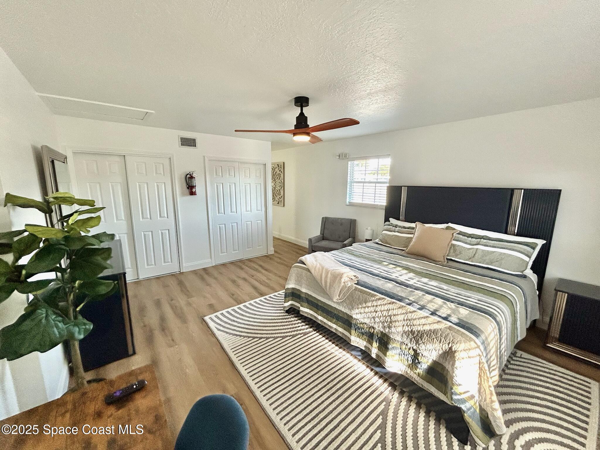 8110 Canaveral Boulevard, Unit 3 Cape Canaveral, FL 32920 - Photo 20 of 25 a bedroom with a bed and a potted plant