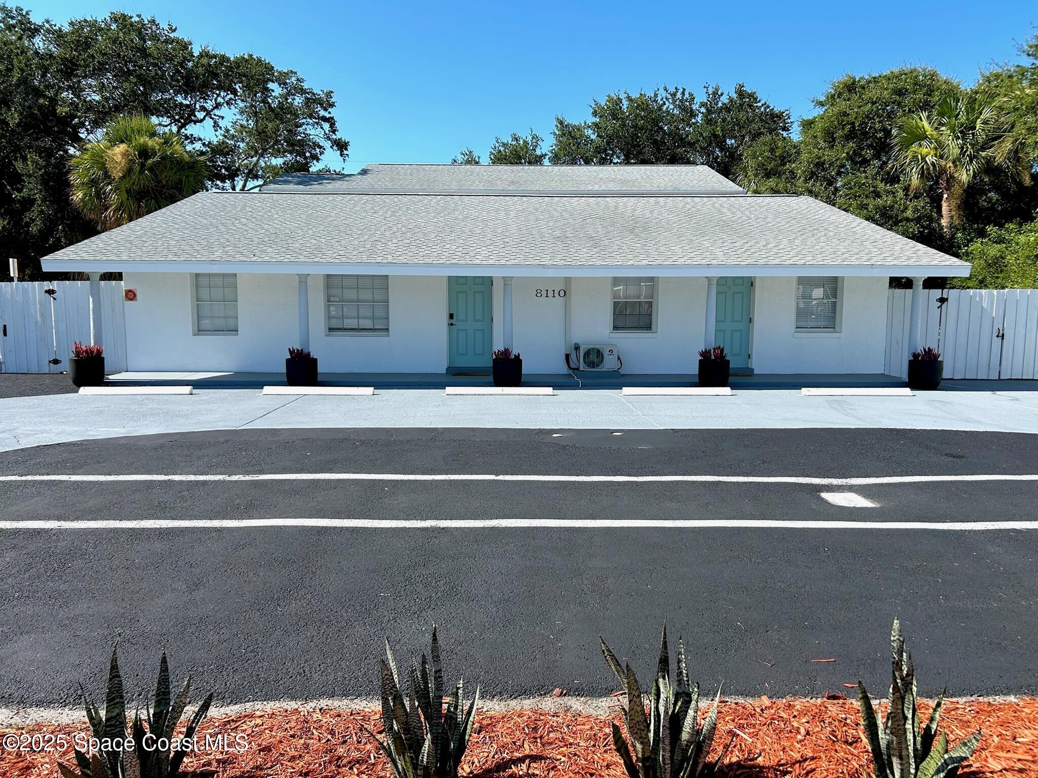 8110 Canaveral Boulevard, Unit 3 Cape Canaveral, FL 32920 - Photo 2 of 25 a front view of a house with a yard