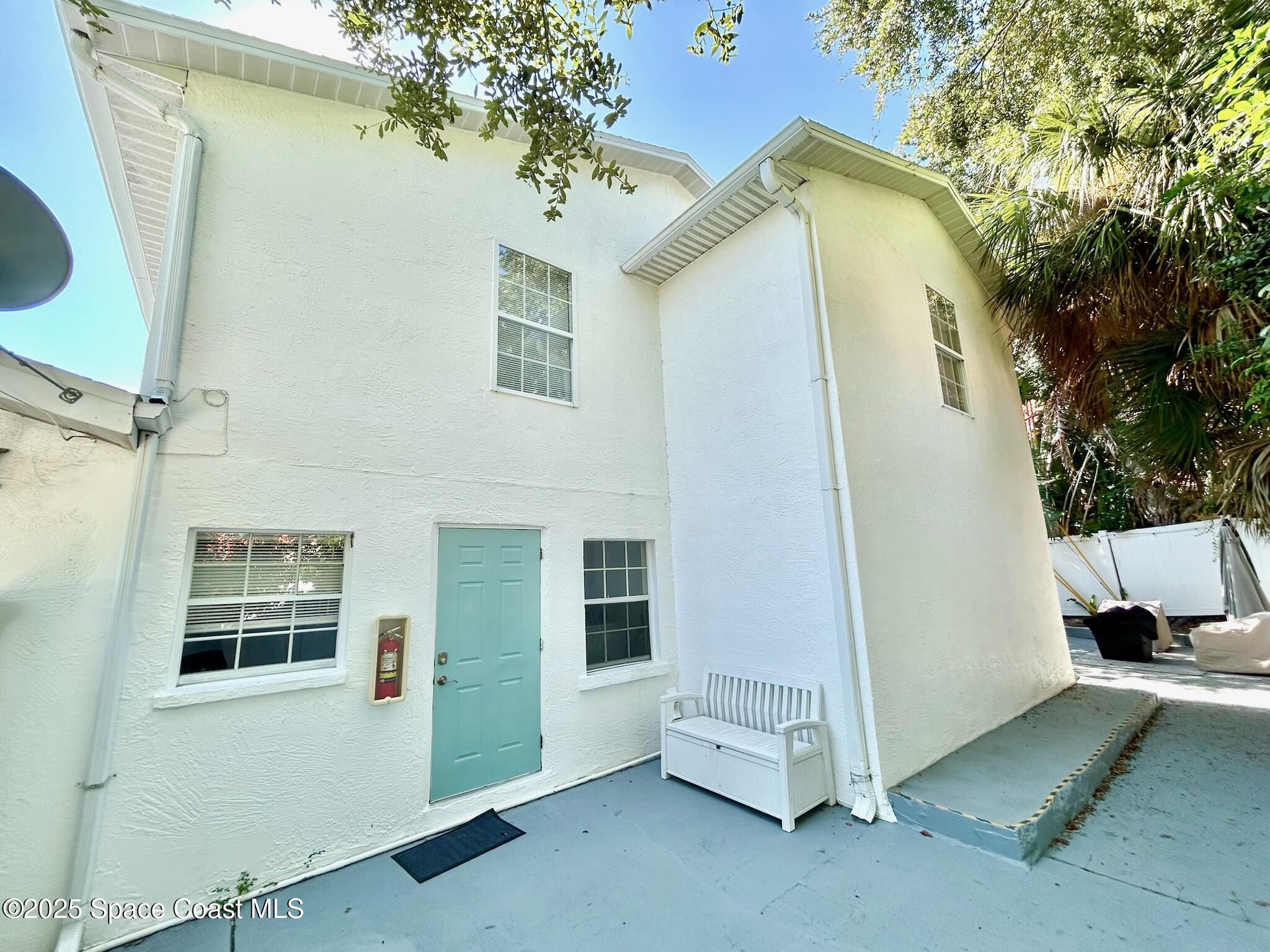 8110 Canaveral Boulevard, Unit 3 Cape Canaveral, FL 32920 - Photo 22 of 25 a view of a house with a door and a tree