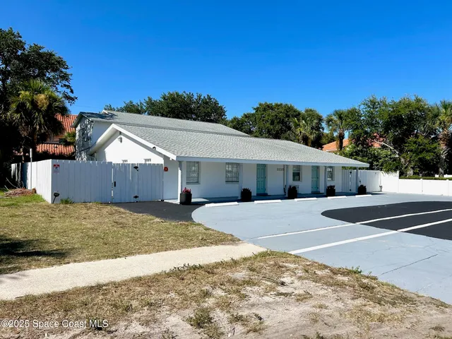 a view of a house with a backyard and garage