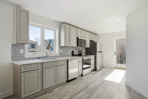 a kitchen with white cabinets and white appliances