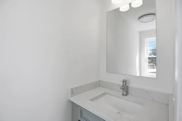 a bathroom with a toilet a sink and mirror