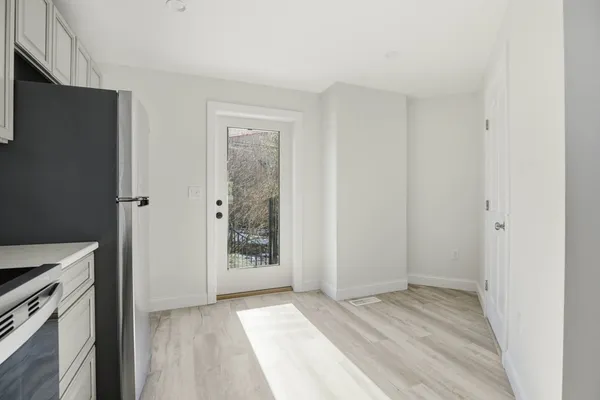 a view of a kitchen with white cabinets and wooden floor