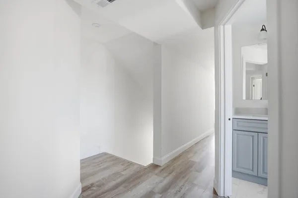 a view of a hallway with wooden floor