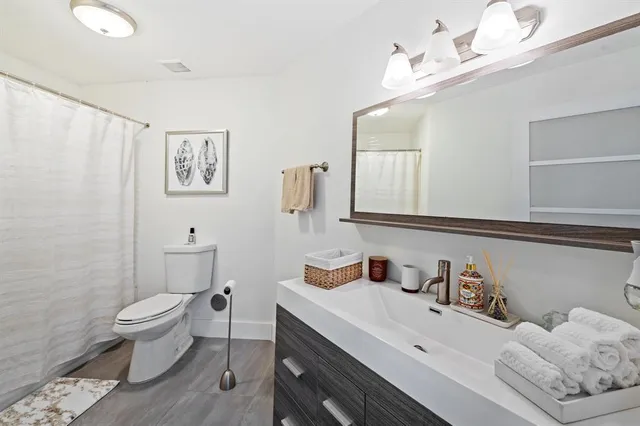 a bathroom with a sink a toilet and a mirror