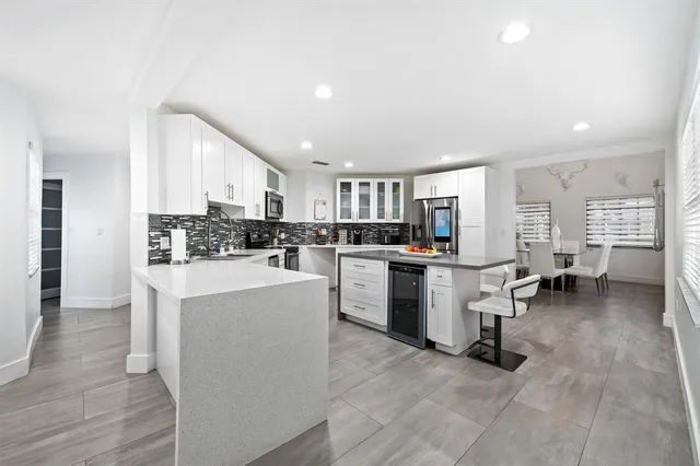 a kitchen with stainless steel appliances white cabinets and a stove top oven
