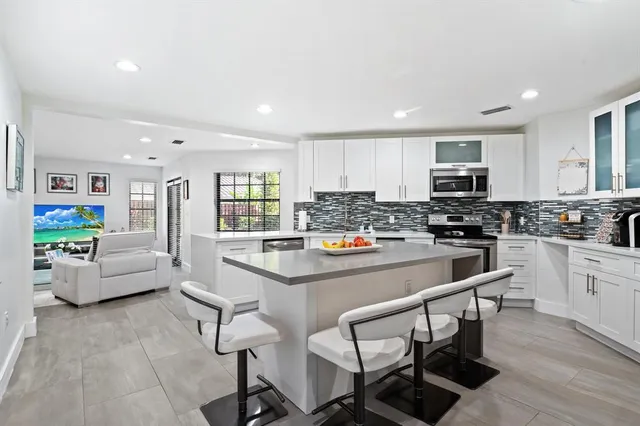 a kitchen with stainless steel appliances white cabinets and wooden floors