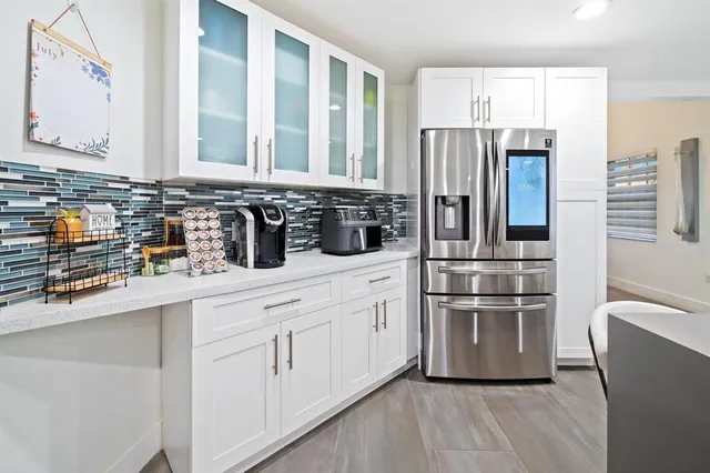 a bedroom with a large bed a large window and potted plant
