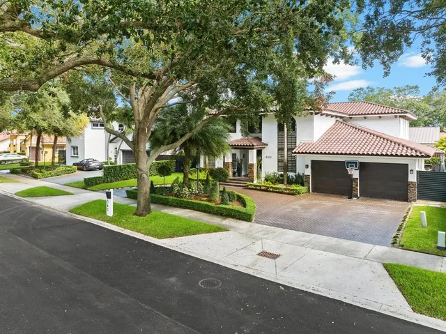 a front view of a house with a yard and trees