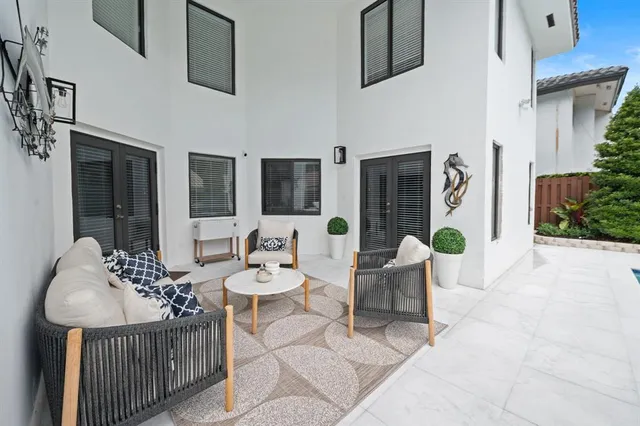 a view of a patio with table and chairs with plants and trees