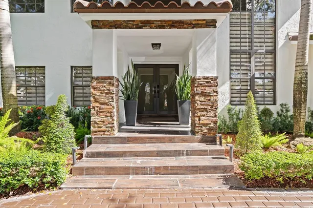 a front view of a house with potted plants