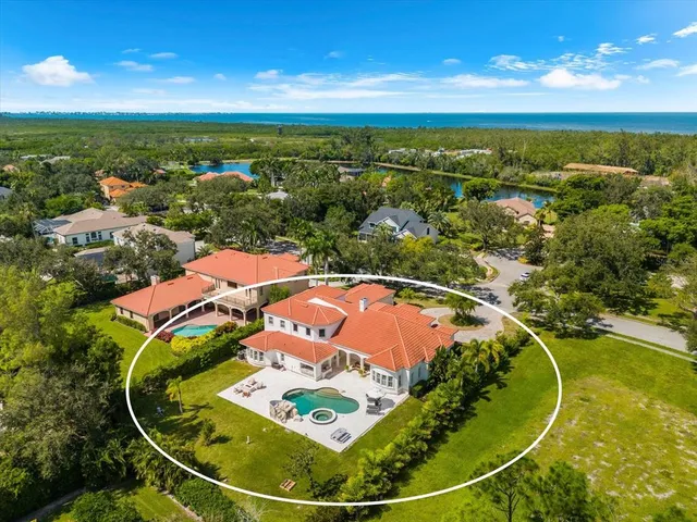 a view of a house with a yard and palm trees