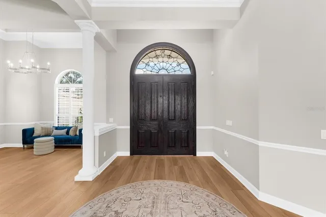 a view of dining room and livingroom with furniture wooden floor a chandelier