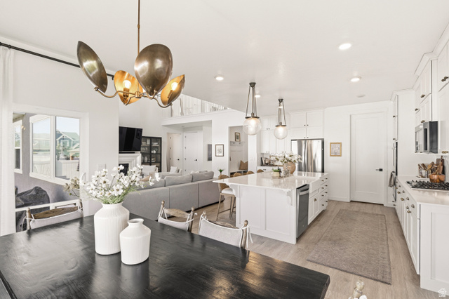 870 North Ada Loop Lehi, UT 84048 - Photo 15 of 51 Open-concept layout featuring a spacious kitchen with white cabinetry, stainless steel appliances, and a large island with a built-in dishwasher