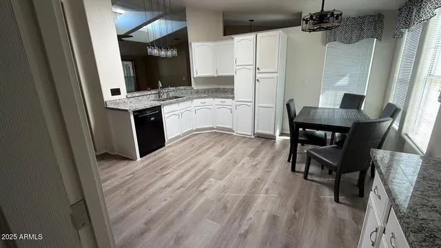 a kitchen with a sink cabinets and wooden floor