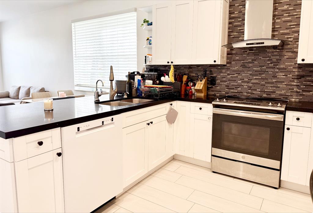 18702 Southwest 27th Street Miramar, FL 33029 - Photo 12 of 17 a kitchen with stainless steel appliances a sink a stove and white cabinets