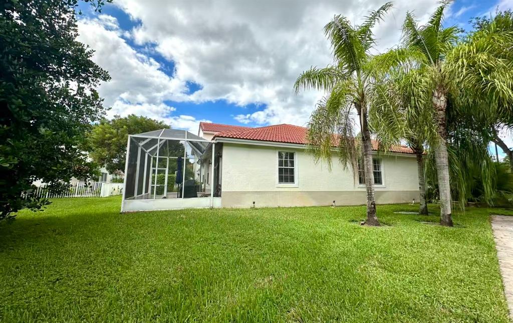 18702 Southwest 27th Street Miramar, FL 33029 - Photo 16 of 17 a view of a house with a yard and tree s