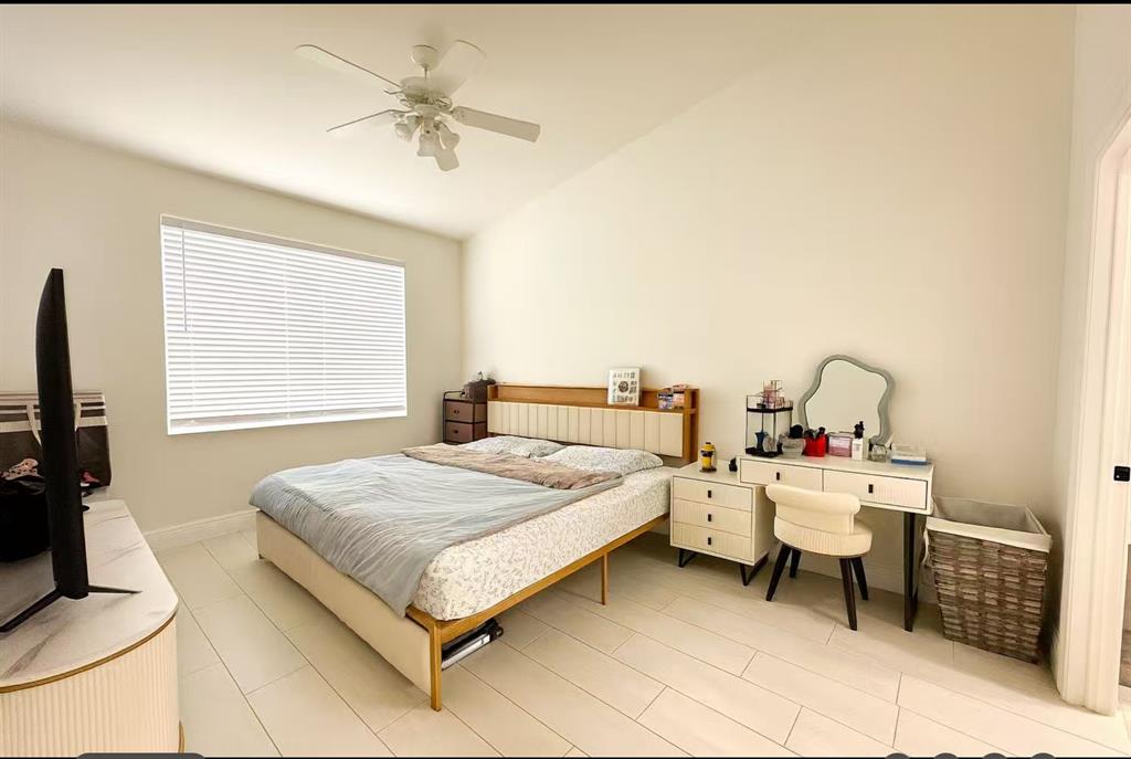 18702 Southwest 27th Street Miramar, FL 33029 - Photo 17 of 17 a bedroom with a bed and a chandelier