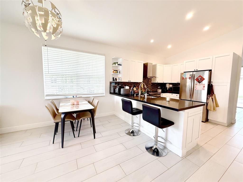 18702 Southwest 27th Street Miramar, FL 33029 - Photo 2 of 17 a kitchen with stainless steel appliances kitchen island granite countertop a sink and a stove