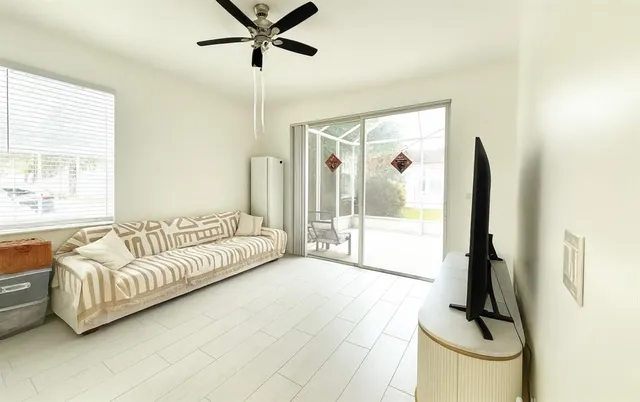a living room with furniture and a floor to ceiling window