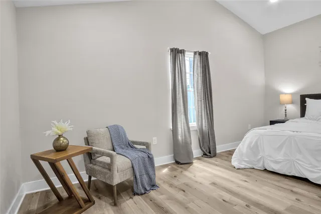 a bedroom with a bed and wooden floor