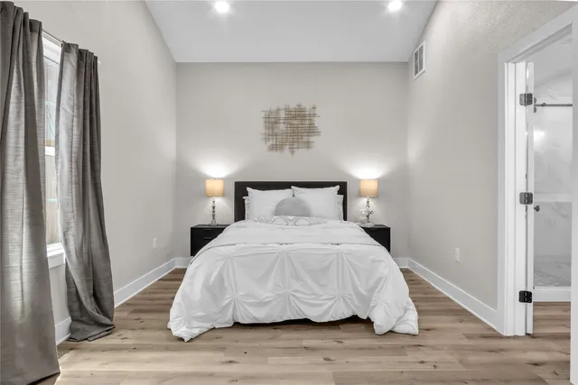 a bedroom with a bed and wooden floor