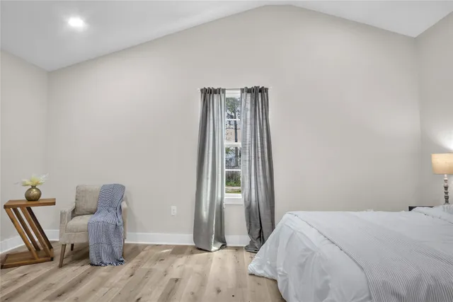 a bedroom with a bed and wooden floor