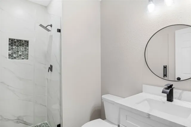 a bathroom with a sink a toilet and a mirror