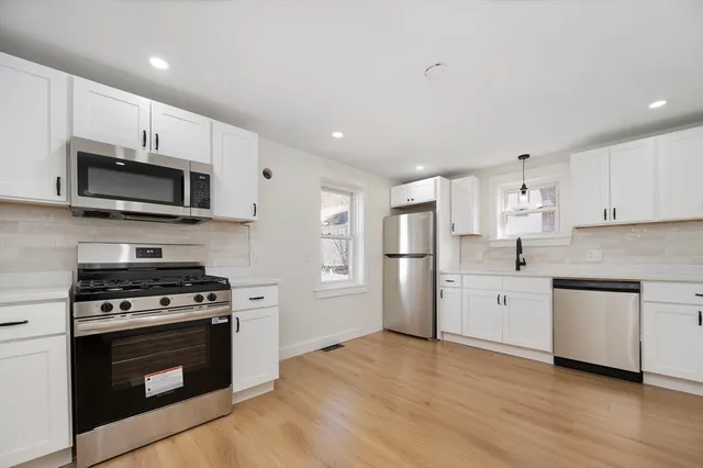 a kitchen with stainless steel appliances a stove a sink and a microwave