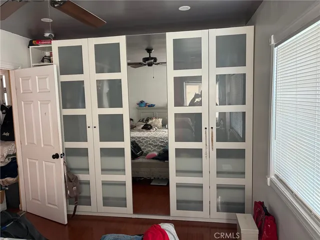 a view of an empty room with wooden floor and windows
