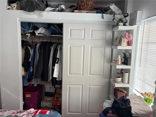 a view of walk in closet with clothes and shoes