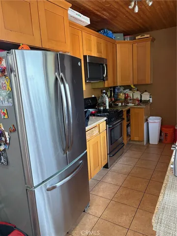 a kitchen with granite countertop a refrigerator and a stove top oven