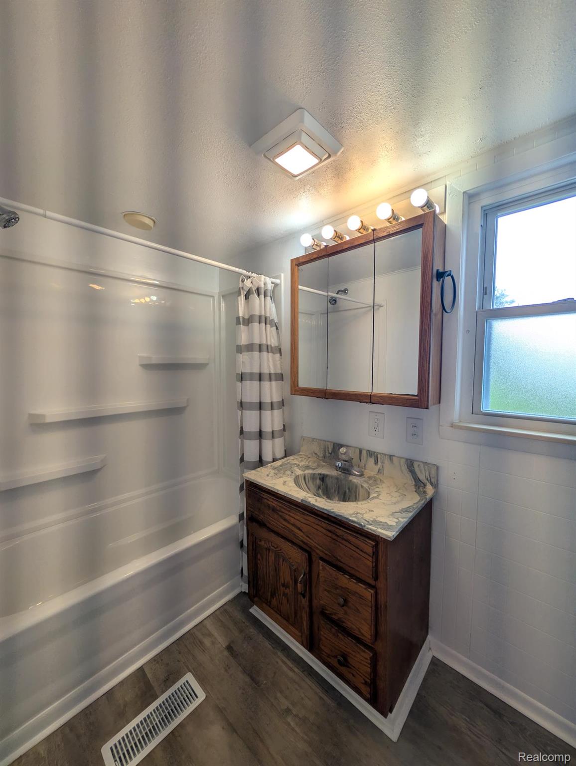 7032 Neff Road Mount Morris, MI 48458 - Photo 15 of 20 Full bathroom featuring vanity, shower / tub combo, dark wood-type flooring, and a textured ceiling