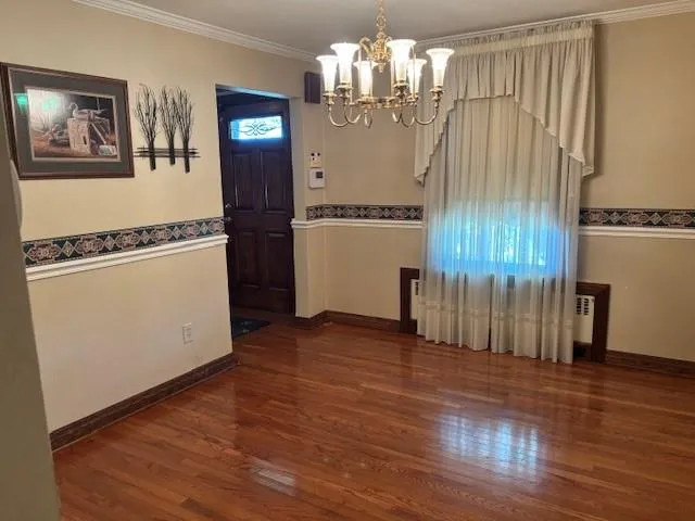 a view of a room with wooden floor and white walls