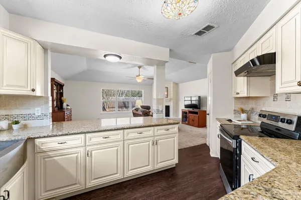 a kitchen with stainless steel appliances granite countertop white cabinets sink and stove