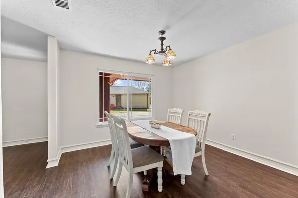 a view of a dining room with furniture wooden floor and chandelier