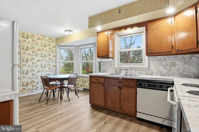 a kitchen with a table chairs and wooden floor