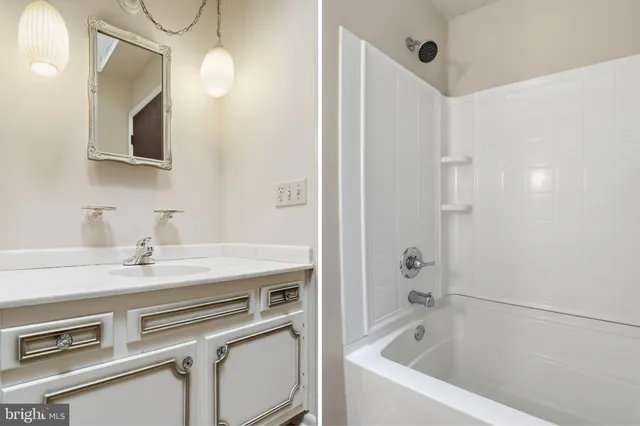 a bathroom with a sink a vanity a mirror and a bathtub
