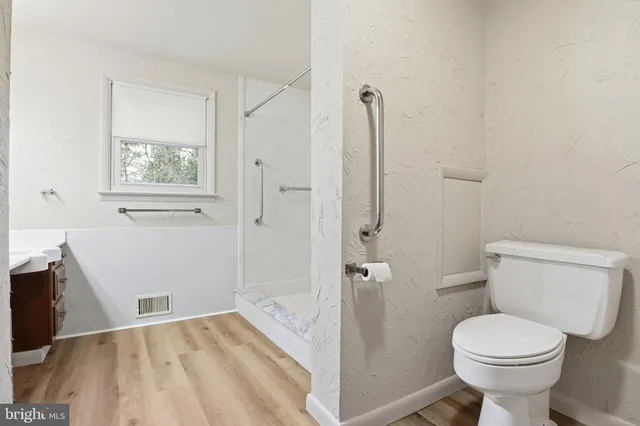 a bathroom with a toilet and a shower