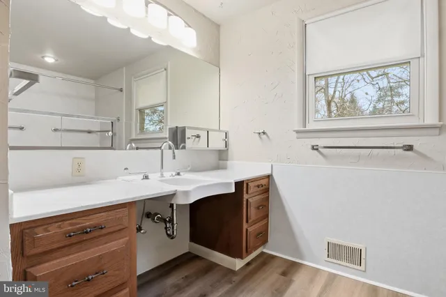 a kitchen with a sink cabinets and wooden floor