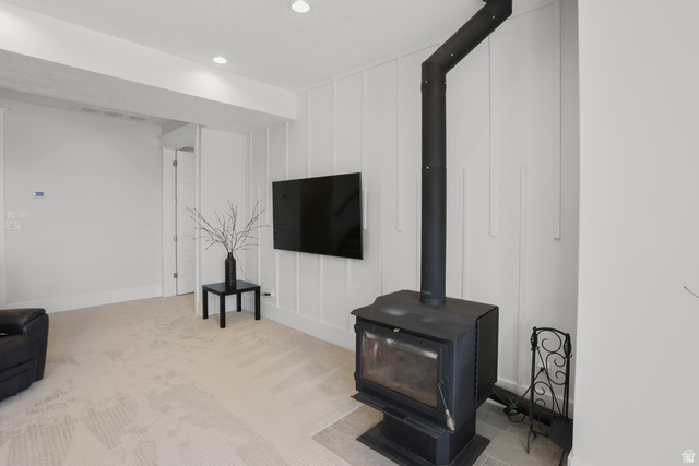 1354 South 800 East Mapleton, UT 84664 - Photo 77 of 129 area featuring a decorative wall, a wood stove, light colored carpet, and recessed lighting