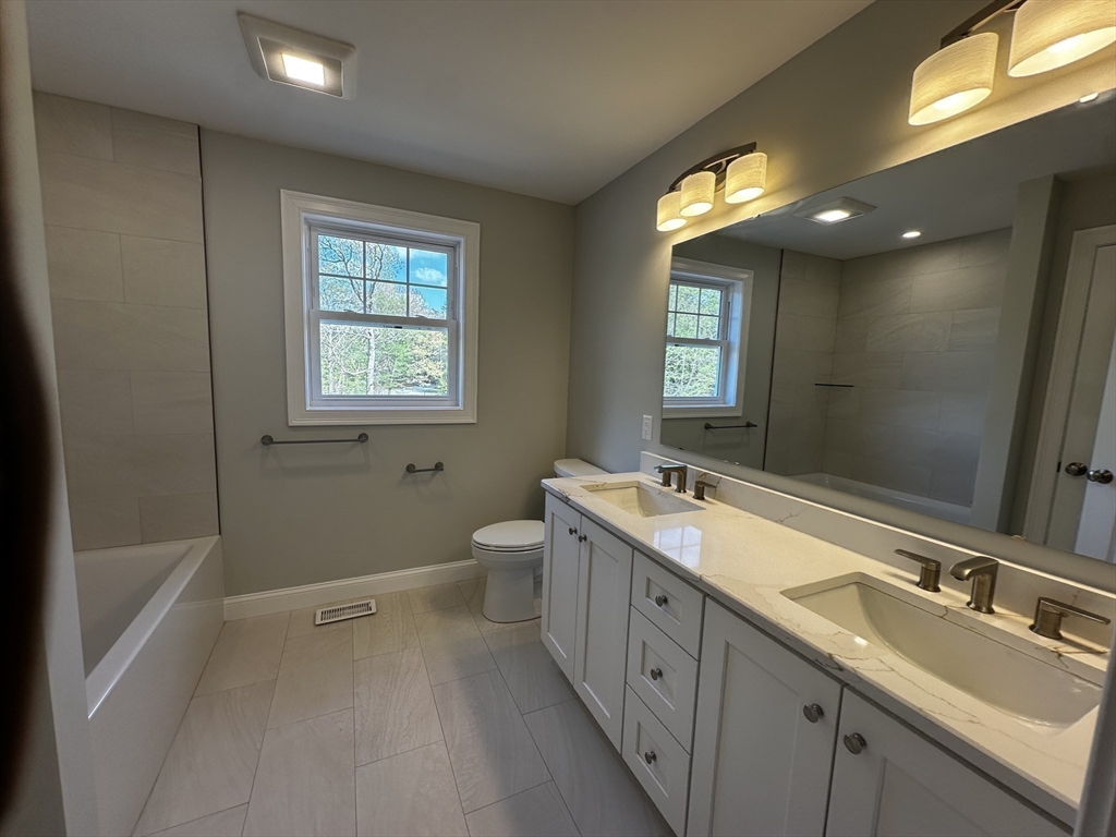56 Dudley Road Billerica, MA 01821 - Photo 13 of 29 a bathroom with a double vanity sink toilet mirror and bathtub