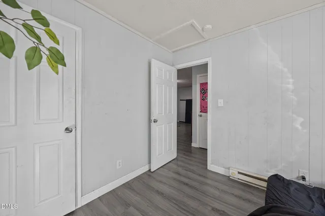 a view of an empty room with wooden floor