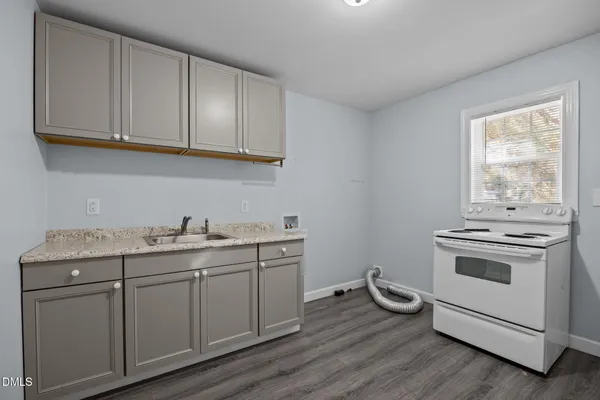 a white refrigerator freezer a stove and a wooden floor