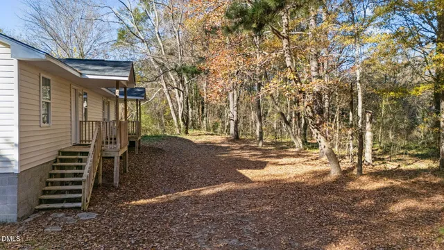 a view of a small house with wooden fence