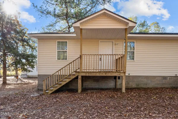a view of a house with a yard chairs and iron fence
