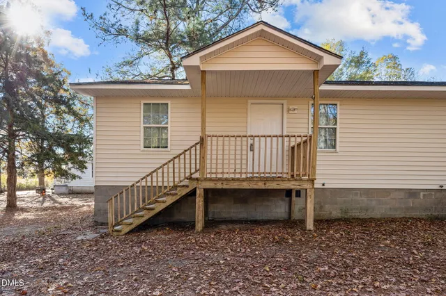 a view of a house with a yard chairs and iron fence